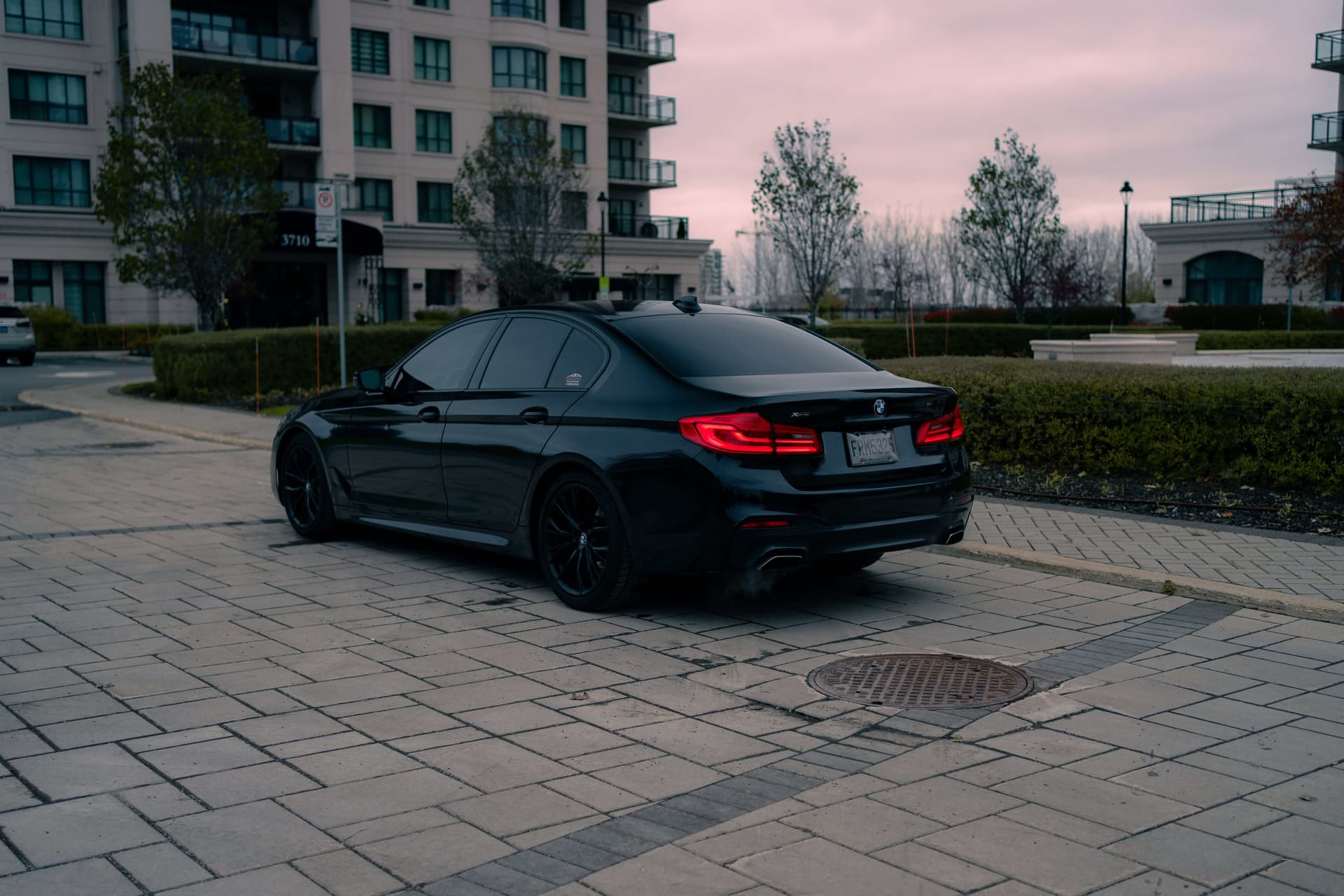 Black BMW 5 Series on a dark reflective studio floor — photo 3