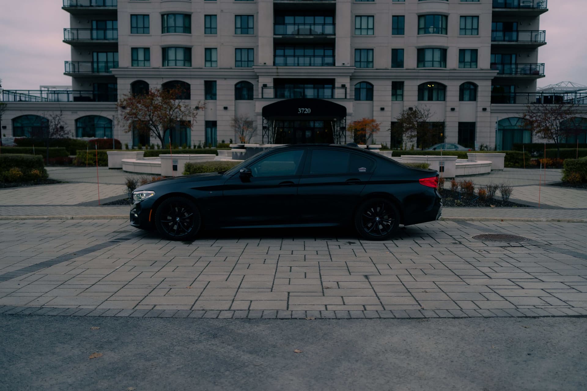 Black BMW 5 Series on a dark reflective studio floor — photo 4
