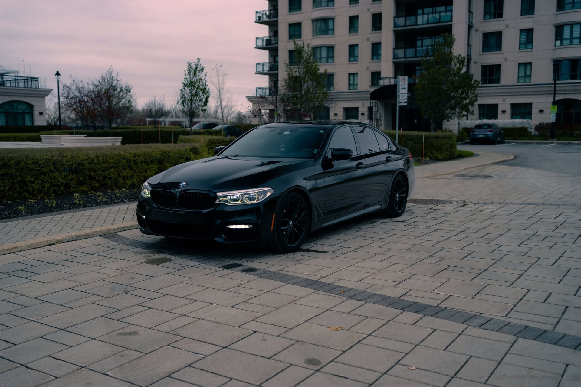 Black BMW 5 Series on a dark reflective studio floor — photo 5