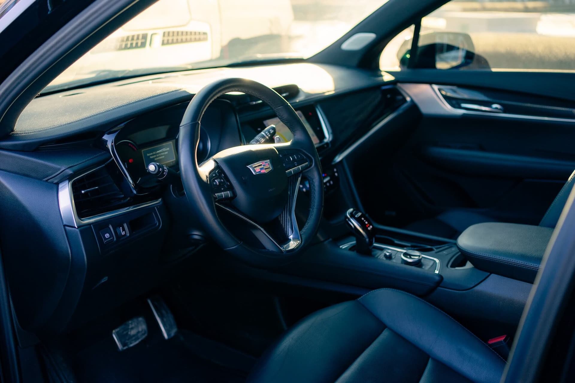 Black Cadillac XT6 luxury SUV in a dark studio with gold accents — photo 2