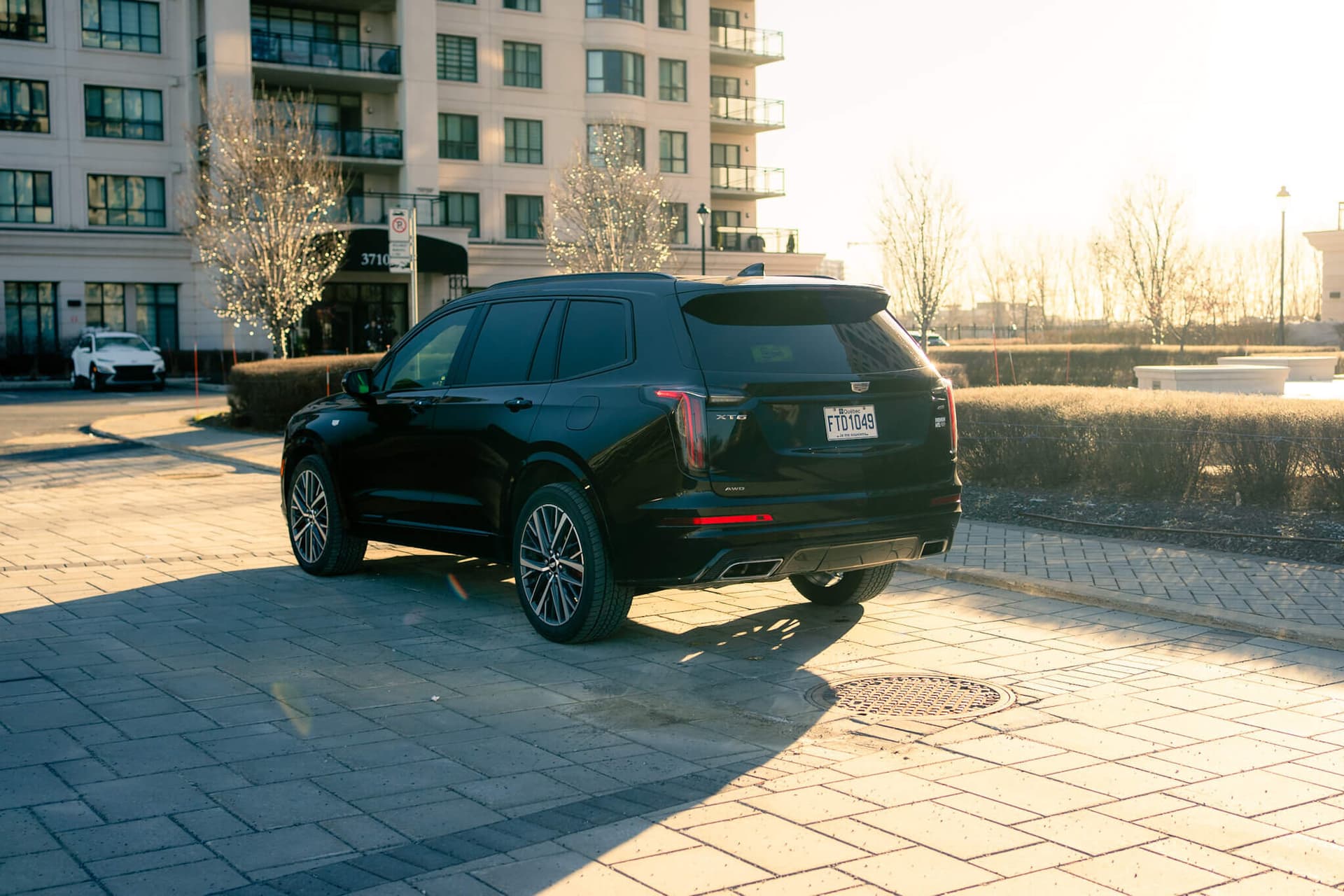 Black Cadillac XT6 luxury SUV in a dark studio with gold accents — photo 3
