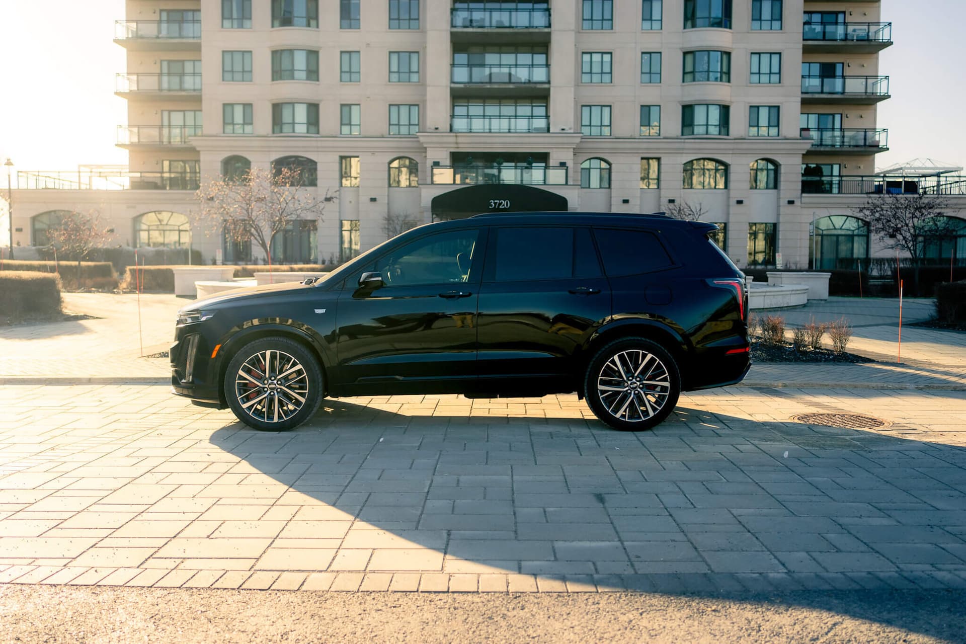 Black Cadillac XT6 luxury SUV in a dark studio with gold accents — photo 4