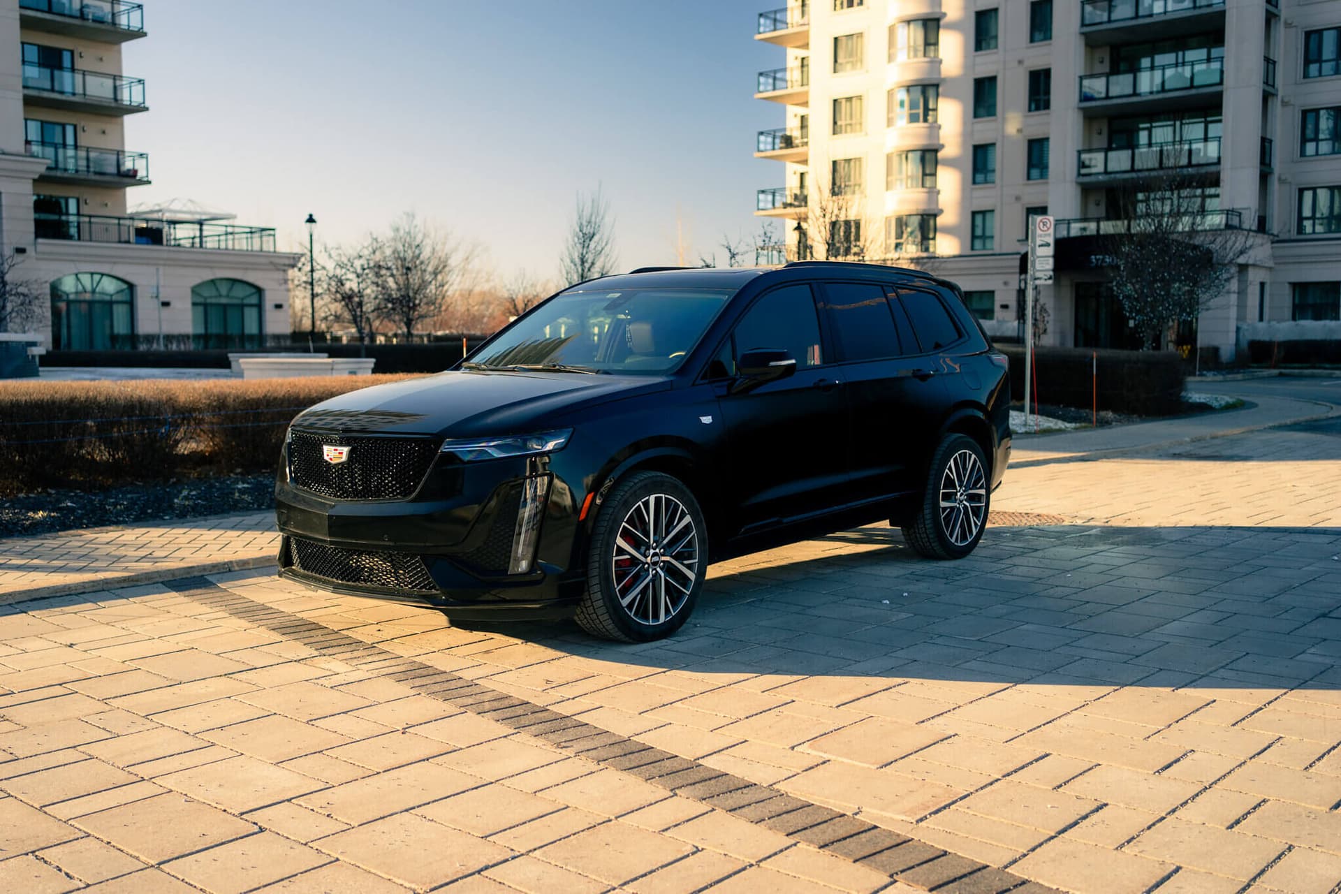 Black Cadillac XT6 luxury SUV in a dark studio with gold accents — photo 5
