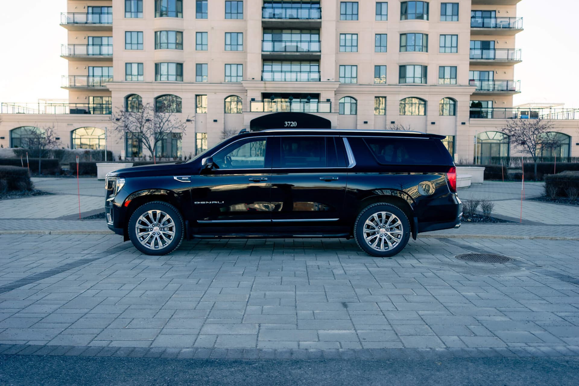 Black GMC Yukon XL on a dark reflective floor with golden edge light — photo 4